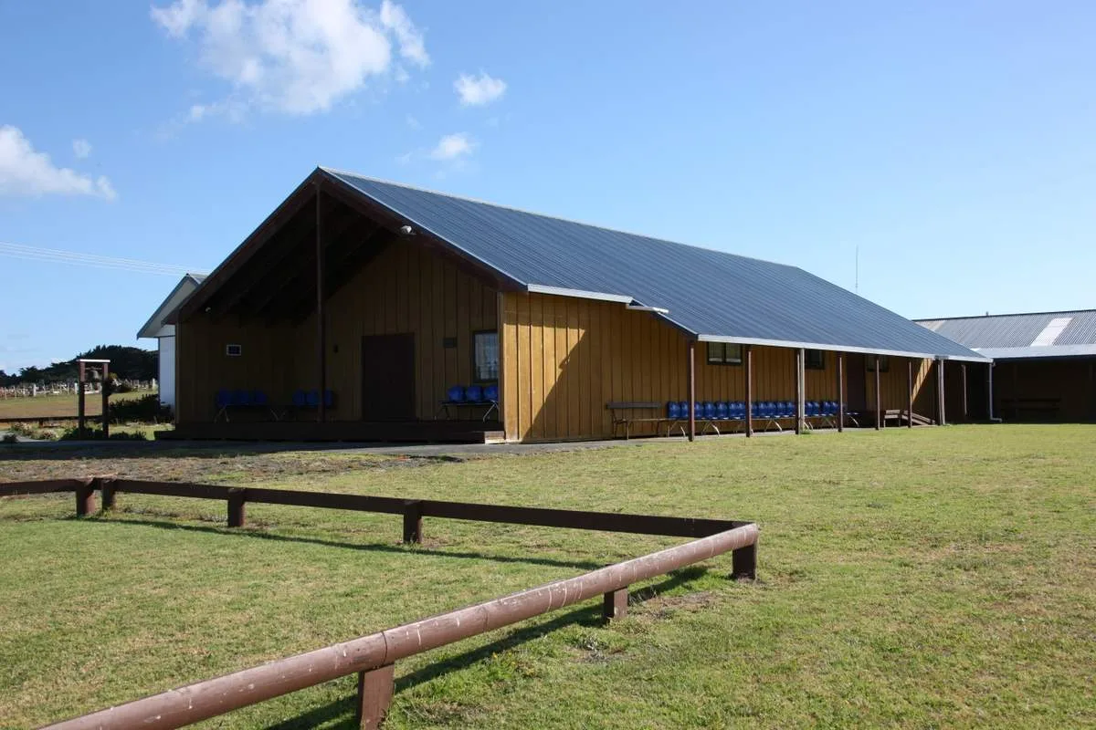 Waikāretu Marae on the Pouto Peninsula: the wharenui and buildings across a grassed marae ātea.