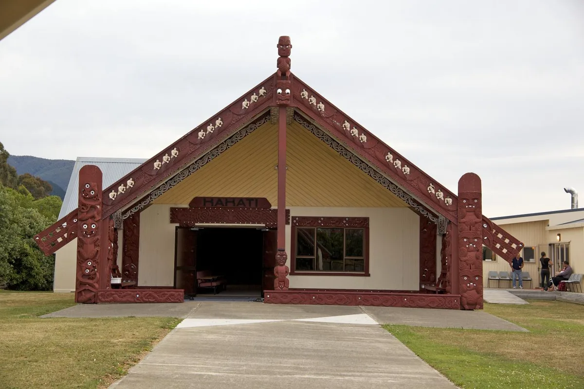 Whakatū Marae: the carved front of the wharenui Kākāti, with a path leading to its doors.